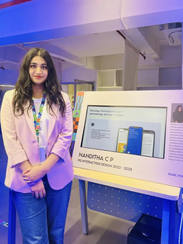 Nanditha beside her project on display at an exhibition.